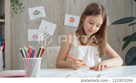 Creative child drawing at the desk at home or school class room Creative child drawing at the desk at home or school class room 122955204