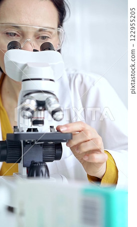 Woman scientist using microscope in laboratory. Microbiology science concept Woman scientist using microscope in laboratory. Microbiology science concept 122955205