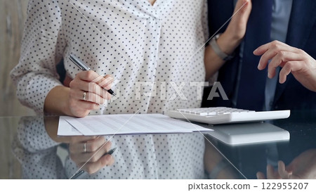 Businesspeople in a meeting with calculator. Sexual harassment is strictly prohibited in the workplace Businesspeople in a meeting with calculator. Sexual harassment is strictly prohibited in the workplace 122955207