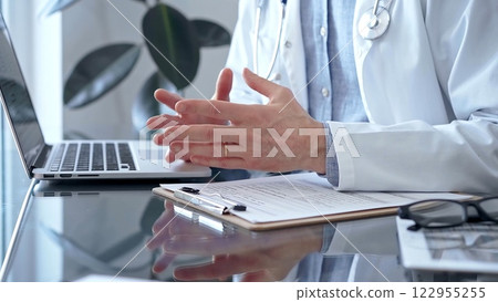 Doctor consulting patient with clipboard and a pen in his hand in medical office. Trust concept in Medicine 122955255