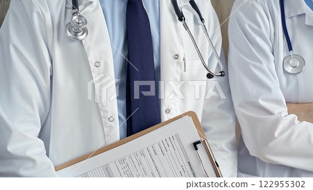 Professional healthcare team in uniform. Two doctors with stethoscopes are standing straight with arms crossed. Medicine concept 122955302