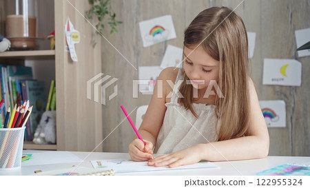 Creative child drawing at the desk at home or school class room 122955324