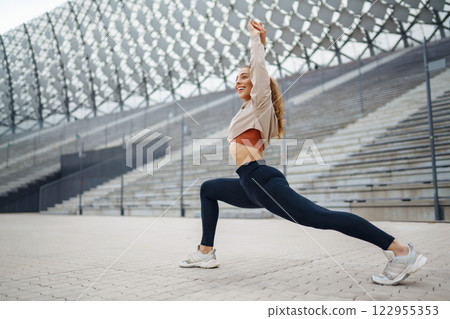 Active lifestyle. Young fitness woman exercising and stretching outdoors. Sports, sports training. Active lifestyle. Young fitness woman exercising and stretching outdoors. Sports, sports training. 122955353