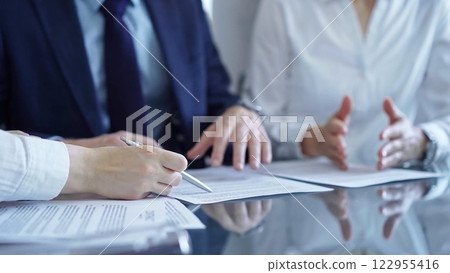 Diverse business people discussing contract papers before signing. Teamwork of lawyers Diverse business people discussing contract papers before signing. Teamwork of lawyers 122955416