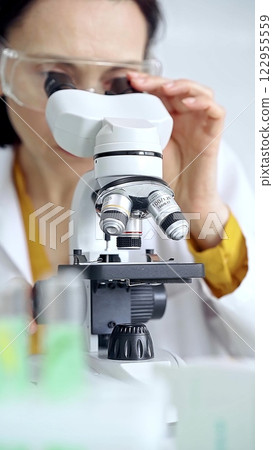 Woman scientist using microscope in laboratory. Microbiology science concept 122955559