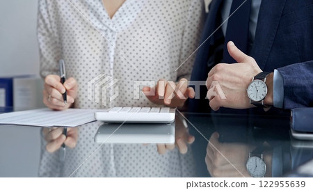 Businesspeople in a meeting with calculator. Sexual harassment is strictly prohibited in the workplace 122955639