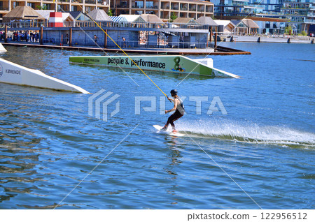 Man wakeboarding in front of modern residential neighborhood at Aarhus in Denmark 122956512