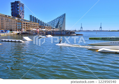 Man wakeboarding in front of modern residential neighborhood at Aarhus in Denmark Man wakeboarding in front of modern residential neighborhood at Aarhus in Denmark 122956540