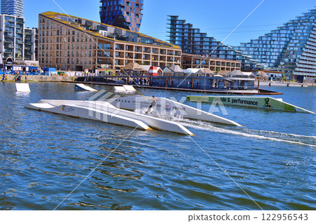 Man wakeboarding in front of modern residential neighborhood at Aarhus in Denmark 122956543
