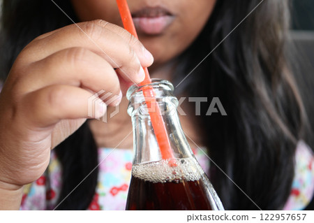 Enjoying a Refreshing Beverage Served in a Glass Bottle with a Straw 122957657