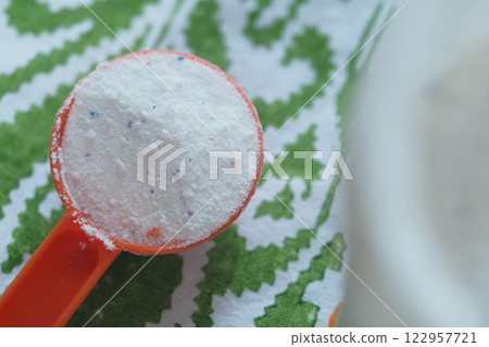 Washing powder in plastic spoon on table  122957721
