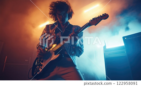 Rock Musician Rocks Out On Electric Guitar With High Energy Performance, Filling The Venue With Electrifying Sound And Dynamic Music. 122958091