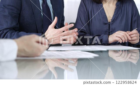Business partners or lawyers are reviewing contract terms during a meeting, negotiating and making decisions together. Business people concept, close up view Business partners or lawyers are reviewing contract terms during a meeting, negotiating and making decisions together. Business people concept, close up view 122958624