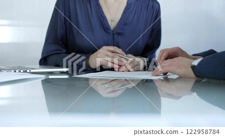 Business colleagues analyzing financial data and collaborating on a project during a productive office meeting while sitting at the glass table. Businesspeople concept 122958784
