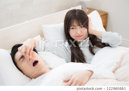 A woman who couldn't sleep because her husband or partner's snoring was so loud she pinched her nose A woman who couldn't sleep because her husband or partner's snoring was so loud she pinched her nose 122960861