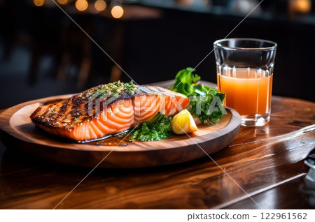 Salmon steak with glass of juice on wood table Salmon steak with glass of juice on wood table 122961562