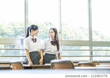 兩個高中女生在課堂上和朋友聊天 122961578
