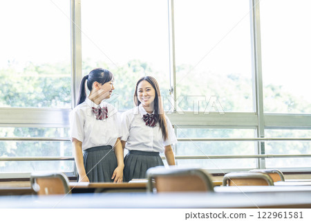 兩個高中女生在課堂上和朋友聊天 122961581