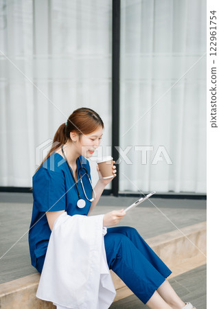 Asian woman part time doctorRepresentation of the daily life of a nurse going to work. Young, confident nurse outside looking away with smile on her face. Asian woman part time doctorRepresentation of the daily life of a nurse going to work. Young, confident nurse outside looking away with smile on her face. 122961754