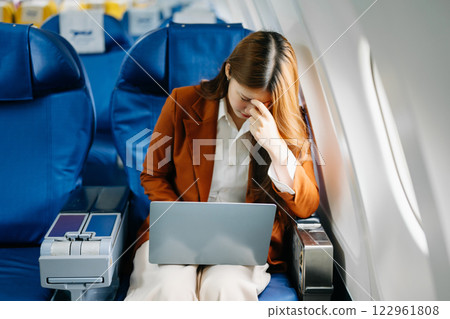 Young Asian executive excels in first class, multitasking with digital tablet, laptop and smartphone Young Asian executive excels in first class, multitasking with digital tablet, laptop and smartphone 122961808