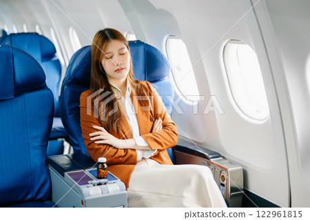 Photo of a frustrated woman sitting on an airplane with her head in her hands Photo of a frustrated woman sitting on an airplane with her head in her hands 122961815
