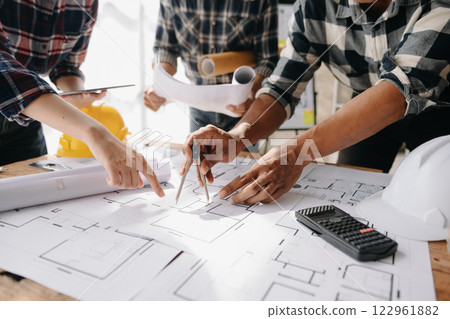 Engineer people meeting working in office for discussing, engineering .Hands of Engineer working on blueprint Construction concept. Engineer people meeting working in office for discussing, engineering .Hands of Engineer working on blueprint Construction concept. 122961882