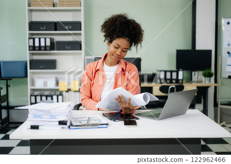 Young businesswoman working with working notepad, tablet and laptop documents talking on the smartphone, tablet 122962466