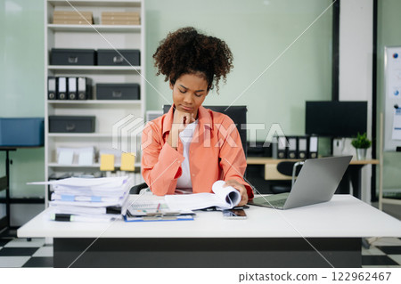Young businesswoman working with working notepad, tablet and laptop documents talking on the smartphone, tablet 122962467