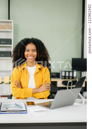 Young businesswoman working with working notepad, tablet and laptop documents talking on the smartphone, tablet 122962492