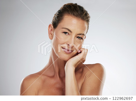 Mature woman, face and skincare routine for healthy glow on grey studio background with mockup space, healthcare wellness or collagen dermatology. Portrait, beauty model and hand on cheek with makeup 122962697
