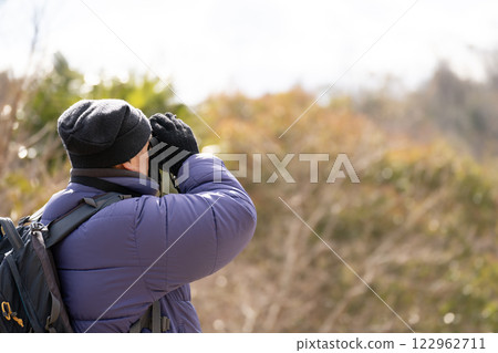 A man watching birds with binoculars A man watching birds with binoculars 122962711