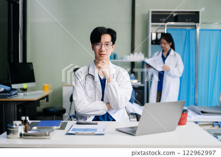 Doctor analyzing patient data on tablet in clinical lab. Medical professional in hospital with laptop, blood samples 122962997