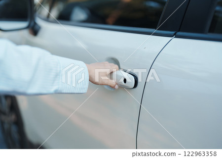 Hand holding smart car handle and opening a door. Transport, travel, service and car rental concept Hand holding smart car handle and opening a door. Transport, travel, service and car rental concept 122963358