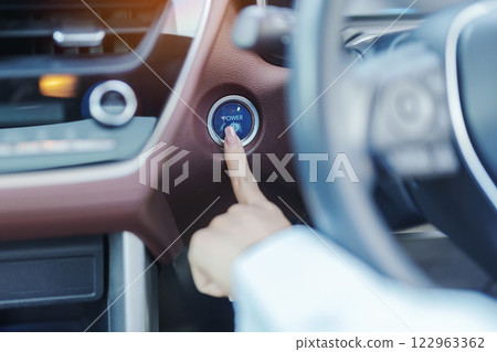 Finger press a car ignition button or START engine inside modern electric automobile. Keyless, change, strategy, vision, innovation and future concept Finger press a car ignition button or START engine inside modern electric automobile. Keyless, change, strategy, vision, innovation and future concept 122963362