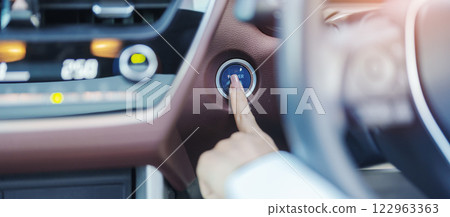 Finger press a car ignition button or START engine inside modern electric automobile. Keyless, change, strategy, vision, innovation and future concept Finger press a car ignition button or START engine inside modern electric automobile. Keyless, change, strategy, vision, innovation and future concept 122963363