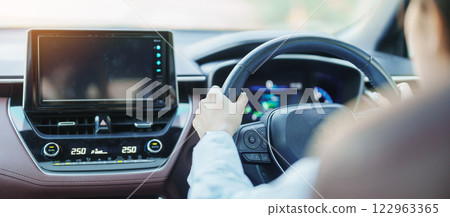 Businesswoman driver driving a car on the road, hand controlling steering wheel in electric modern automobile. Journey, trip and safety Transportation concepts 122963365