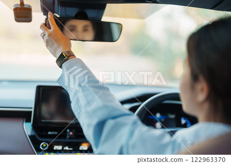 Business woman driver adjusting rear view mirror a car. Journey, trip and safety Transportation concepts Business woman driver adjusting rear view mirror a car. Journey, trip and safety Transportation concepts 122963370