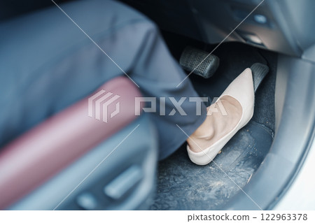 Female driver in high heels, business woman driving car and pushing car break and accelerator pedal. Safety concept Female driver in high heels, business woman driving car and pushing car break and accelerator pedal. Safety concept 122963378