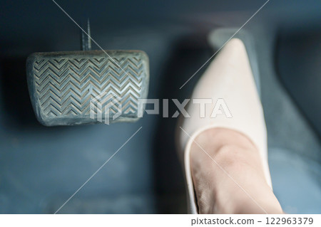 Female driver in high heels, business woman driving car and pushing car break and accelerator pedal. Safety concept Female driver in high heels, business woman driving car and pushing car break and accelerator pedal. Safety concept 122963379