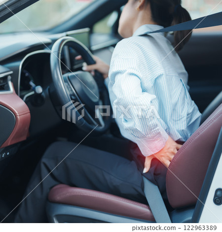 woman with her back sprain while driving car long time, back body ache due to Piriformis Syndrome, Low Back Pain and Spinal Compression. Ergonomic and medical concept woman with her back sprain while driving car long time, back body ache due to Piriformis Syndrome, Low Back Pain and Spinal Compression. Ergonomic and medical concept 122963389