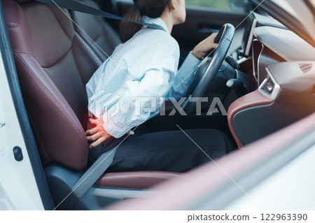 woman with her back sprain while driving car long time, back body ache due to Piriformis Syndrome, Low Back Pain and Spinal Compression. Ergonomic and medical concept 122963390