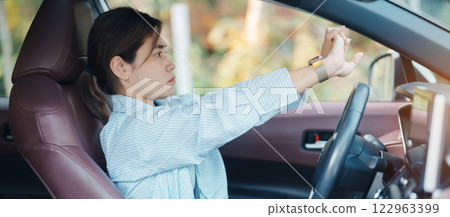 woman feeling sleepy and yawn during drive car long time. Asian girl tired and fatigue having headache after driving car in traffic jam. Sleep, stretching and safety concept 122963399