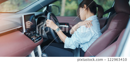 woman with her shoulder and neck sprain while driving car long time, muscle painful. Shoulder ache, Scapular pain, office syndrome and ergonomic concept woman with her shoulder and neck sprain while driving car long time, muscle painful. Shoulder ache, Scapular pain, office syndrome and ergonomic concept 122963410