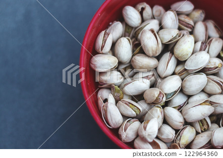 Delicious Pistachios in a Deep Red Bowl Close-up 122964360