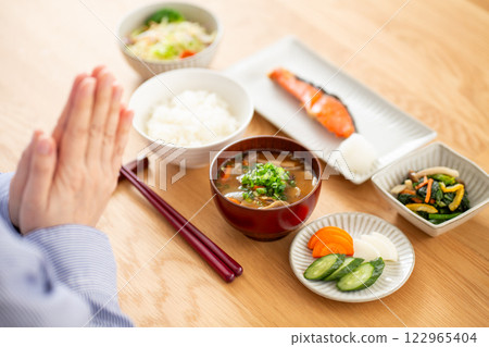 A middle-aged woman eating a Japanese breakfast of grilled salmon 122965404