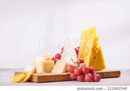 A delectable arrangement of various cheeses, fresh grapes 122965540