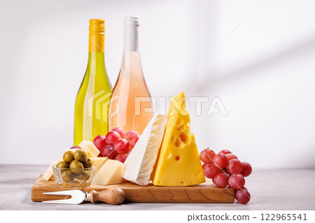 A delectable arrangement of various cheeses, fresh grapes, and wine 122965541