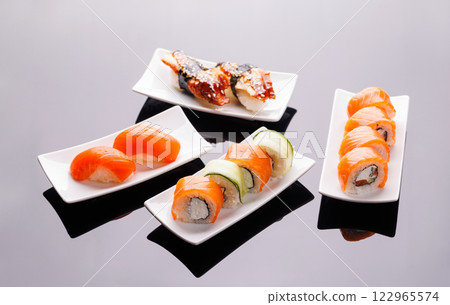 Assorted sushi and maki rolls beautifully arranged on plates 122965574