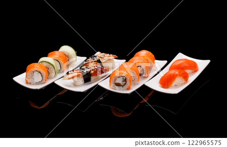 Assorted sushi and maki rolls beautifully arranged on plates 122965575