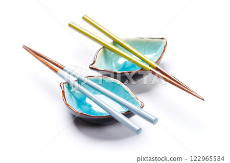 A sushi chopsticks and a small bowls, elegantly arranged on a clean white background 122965584